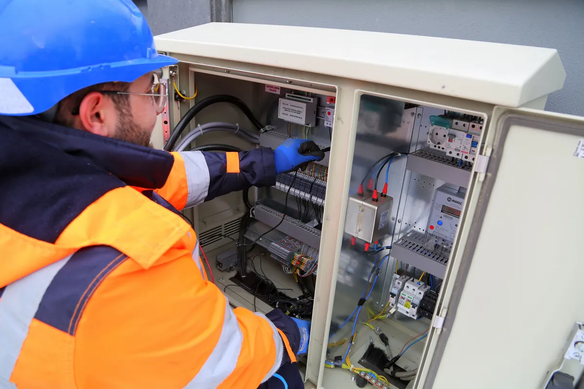 GRC Teknoloji mühendisi bir elektrik panosunda çalışıyor